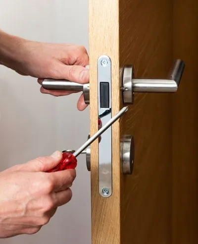 A Locksmith technician installing a residential deadbolt lock in Coker, AL